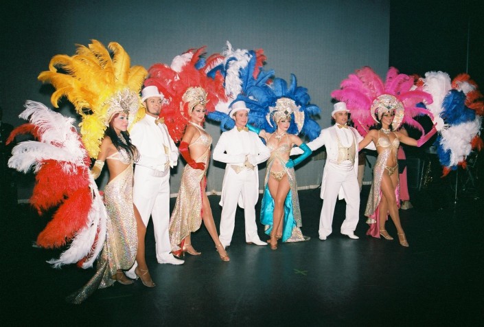 Vegas showgirls and entertainers in white and multi-color